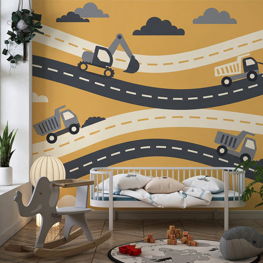 Kids-Mundo dump truck and digger mural behind a bed in an active mustard kids bedroom.