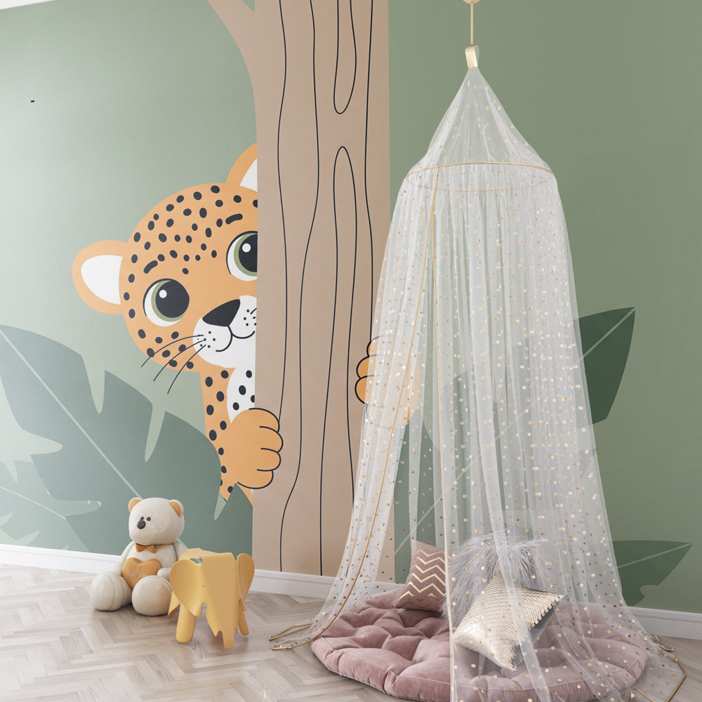 Safari themed nursery featuring playful leopard wallpaper with tropical leaves and soft green tones