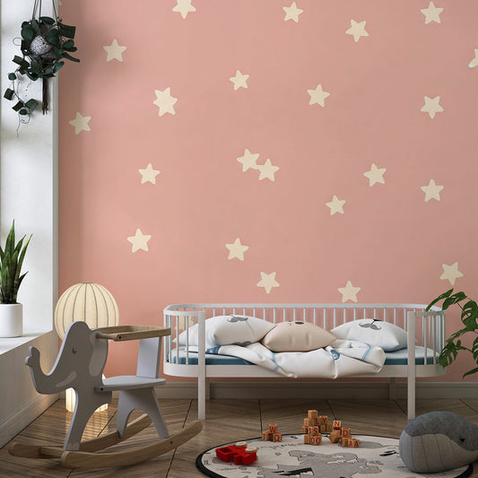Kids-Mundo pink star wall mural on a feature wall in a toddler's bedroom with soft toys nearby.