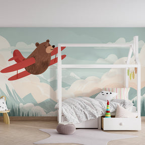Adventure bear flying airplane mural wallpaper for children's bedroom with calming blue tones