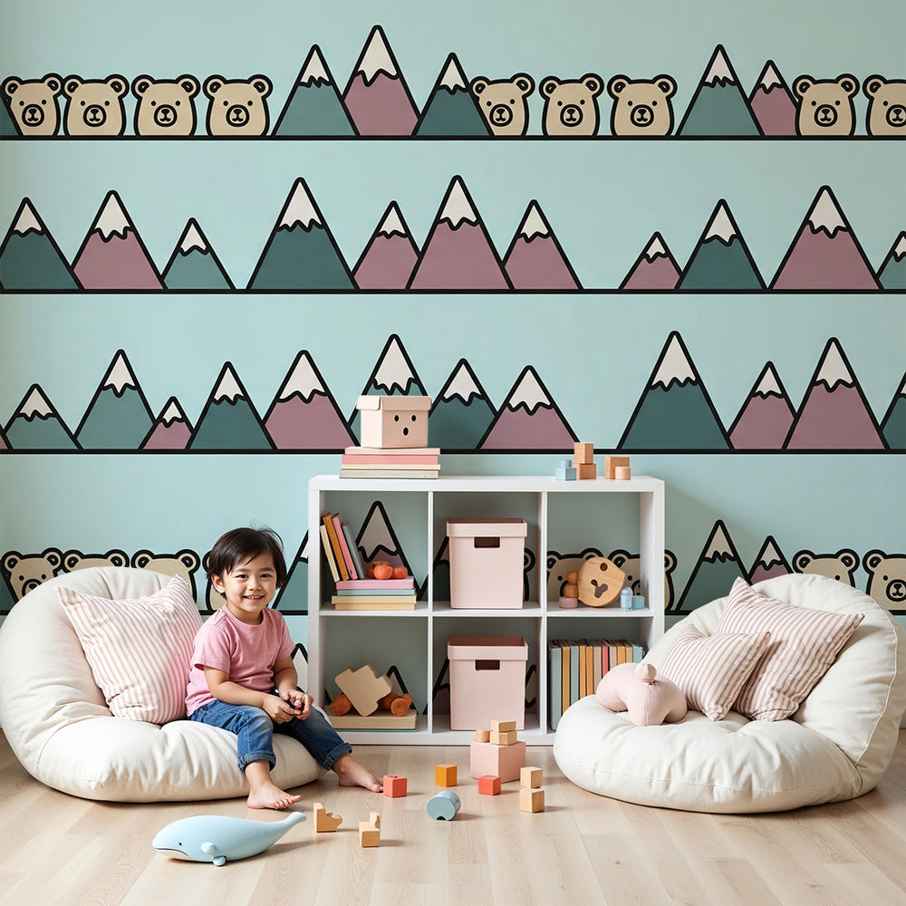 Kids-Mundo mountain wall mural in a pale blue nursery, made to measure with playful bears peeking over the peaks.