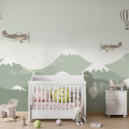 Kids-Mundo balloon and biplane mural styled above a cot in a soft green nursery