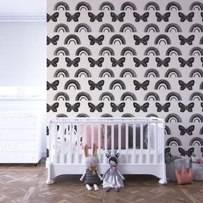Black butterfly and rainbow wallpaper creating magical atmosphere in children's bedroom interior