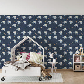 Navy blue elephant mural wallpaper with crescent moons in cozy kids room setting