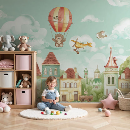 Kids-Mundo enchanted balloon village wall mural in a soft pastel nursery with a cot