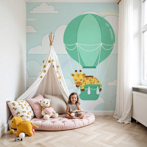 Giraffe hot air balloon mural wallpaper in modern nursery room with soft blue sky design by Kids-Mundo
