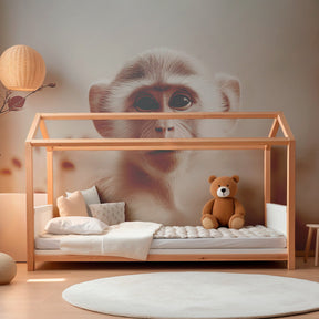 Safari monkey mural wallpaper with foliage elements in cozy kids playroom setting