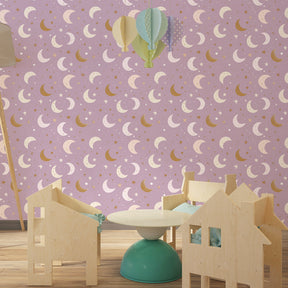 Soft pink celestial wallpaper with moon motifs decorating little girl's bedroom by Kids-Mundo