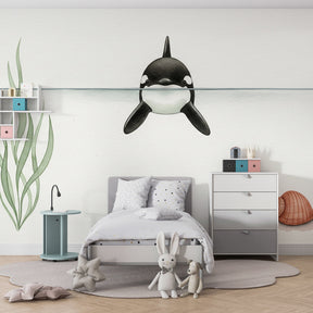Marine life wallpaper featuring playful orca in children's bedroom with natural wood furniture