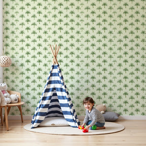 Green palm tree mural wallpaper in bright nursery with wooden crib by Kids-Mundo