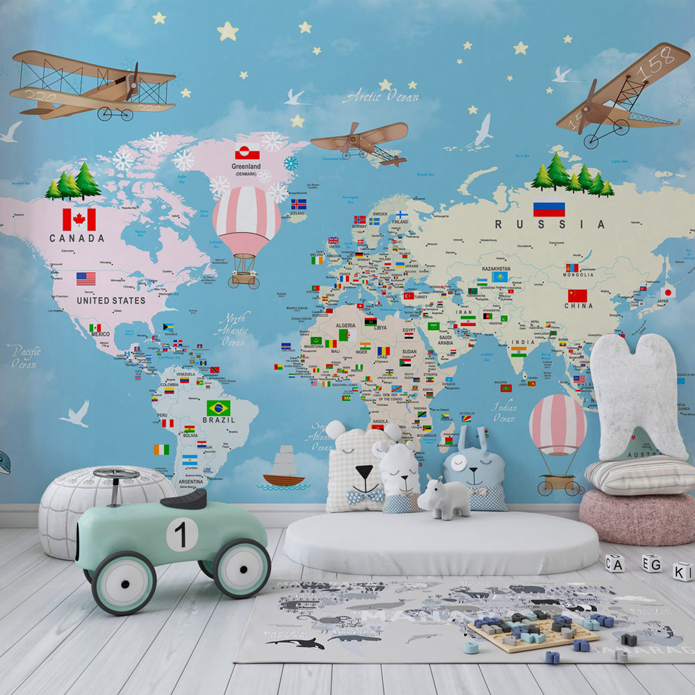 Kids-Mundo pastel world map mural in a playroom, dolphins and penguins dotted around a colourful flag map.