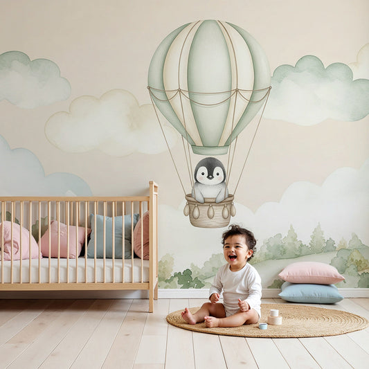 Kids-Mundo penguin hot air balloon wall mural styled behind a cot in a soft sage-green nursery
