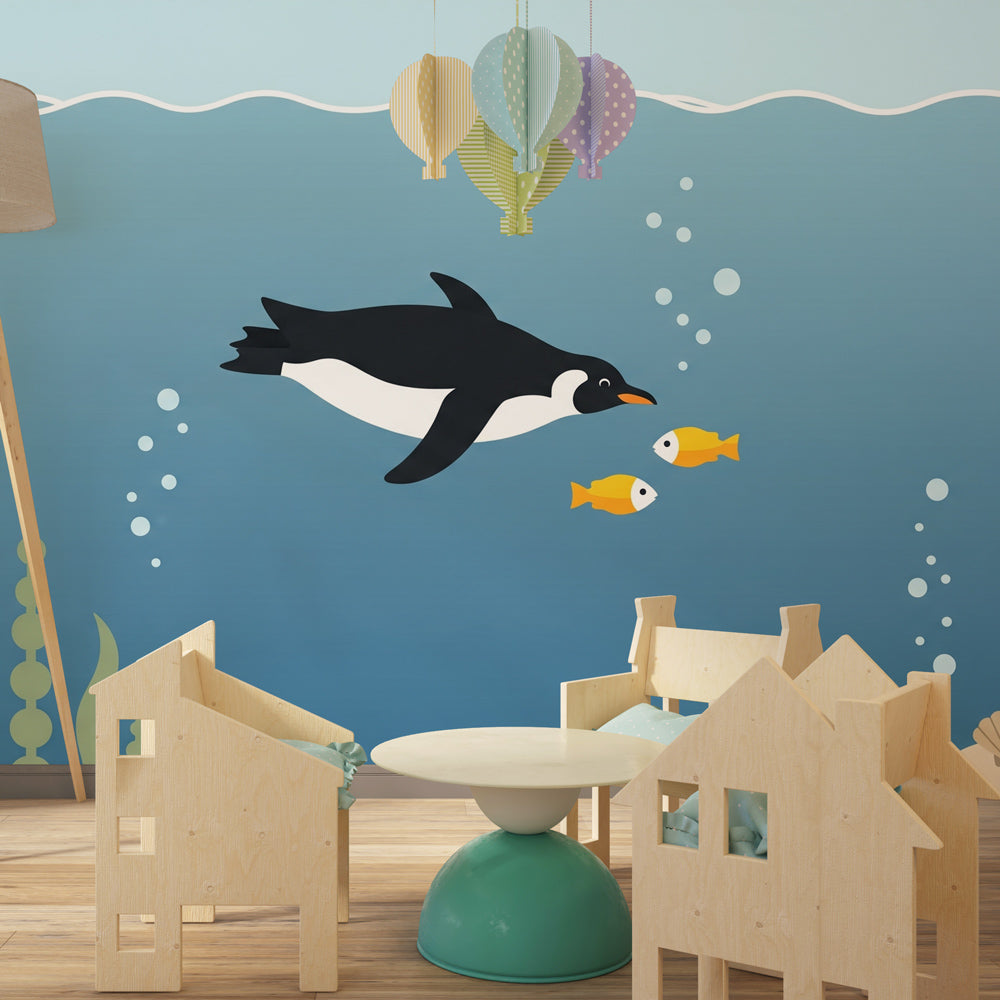 Ocean themed mural wallpaper featuring penguin and colorful fish in children's playroom
