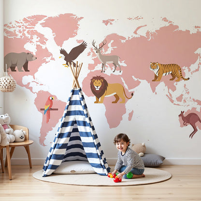 Kids-Mundo blush-pink world map wall mural with animal illustrations behind a cot in a nursery