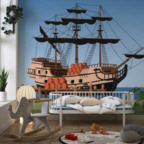 Pirate ship wallpaper in baby nursery with wooden furniture and ocean theme