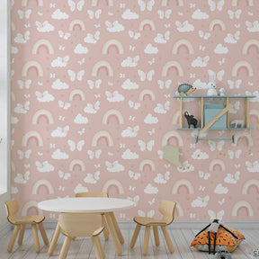 Whimsical rainbow and butterfly wallpaper creating magical atmosphere in kids bedroom with pink accents
