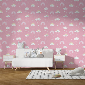 Smiling clouds and rainbow wallpaper decorating cozy toddler bedroom with pink accents