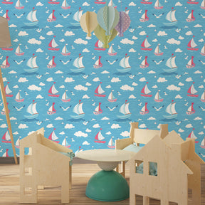 Coastal playroom design with sailboat mural wallpaper showing boats sailing across sunny blue skies