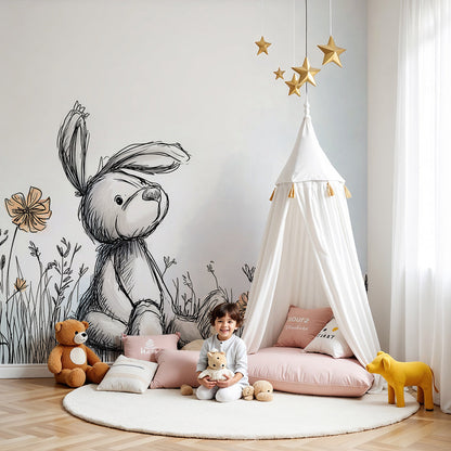 Kids-Mundo bunny wall mural in a soft nursery with a cot and pale wildflower meadow backdrop