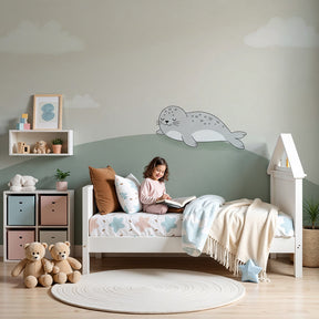 Sleeping seal mural wallpaper in peaceful baby nursery with natural wood crib by Kids-Mundo