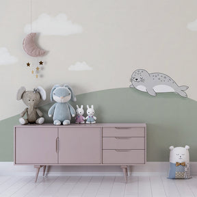Baby room featuring sleeping seal wallpaper with soft green hill and cloud design
