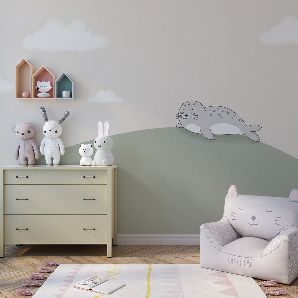 Complete nursery setup with sleeping seal mural wallpaper and matching pastel accessories