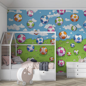 Sports themed mural wallpaper creating energetic playroom atmosphere with floating footballs