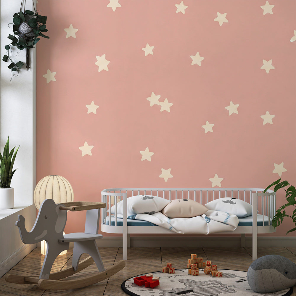Kids-Mundo pink star wall mural on a feature wall in a toddler's bedroom with soft toys nearby.