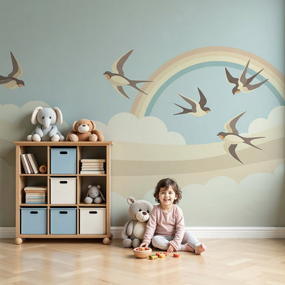 Kids-Mundo swallow and rainbow wall mural styled in a soft pastel nursery with a cot and gentle lighting.