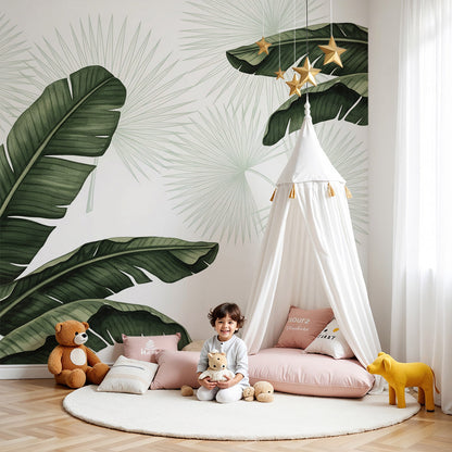 Kids-Mundo banana leaf wall mural in a bright nursery with a cot and lush tropical print