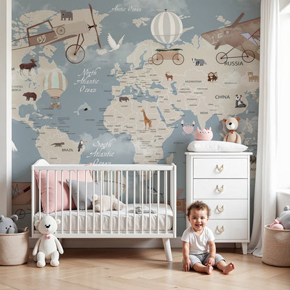 Kids-Mundo animal world map wall mural in a nursery, giraffes and pandas dotted around a soft blue-grey map.