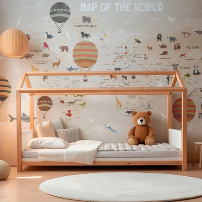 Kids-Mundo storybook world map mural in a playroom, penguins and orcas dotted around a warm-toned map.